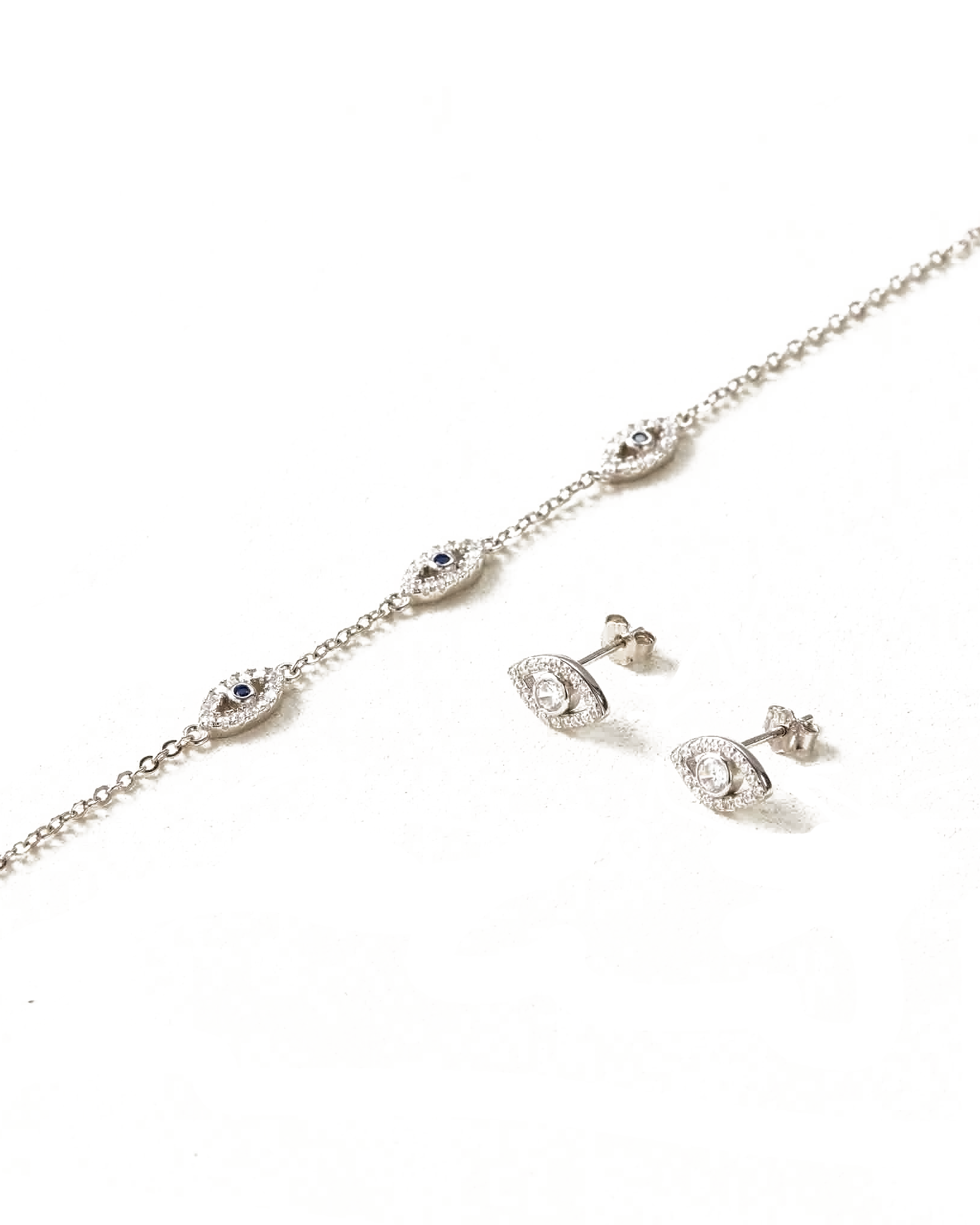 Silver necklace and earrings set on a white background
