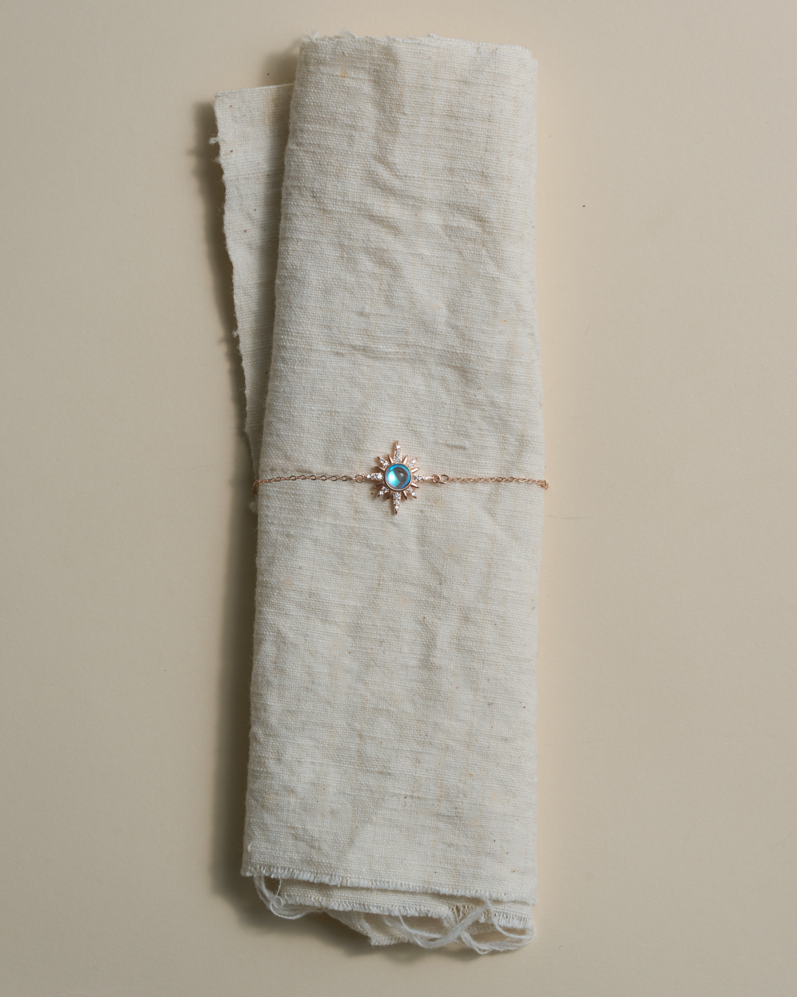 Choodo sun moonstone silver chain necklace wrapped around textured natural linen fabric