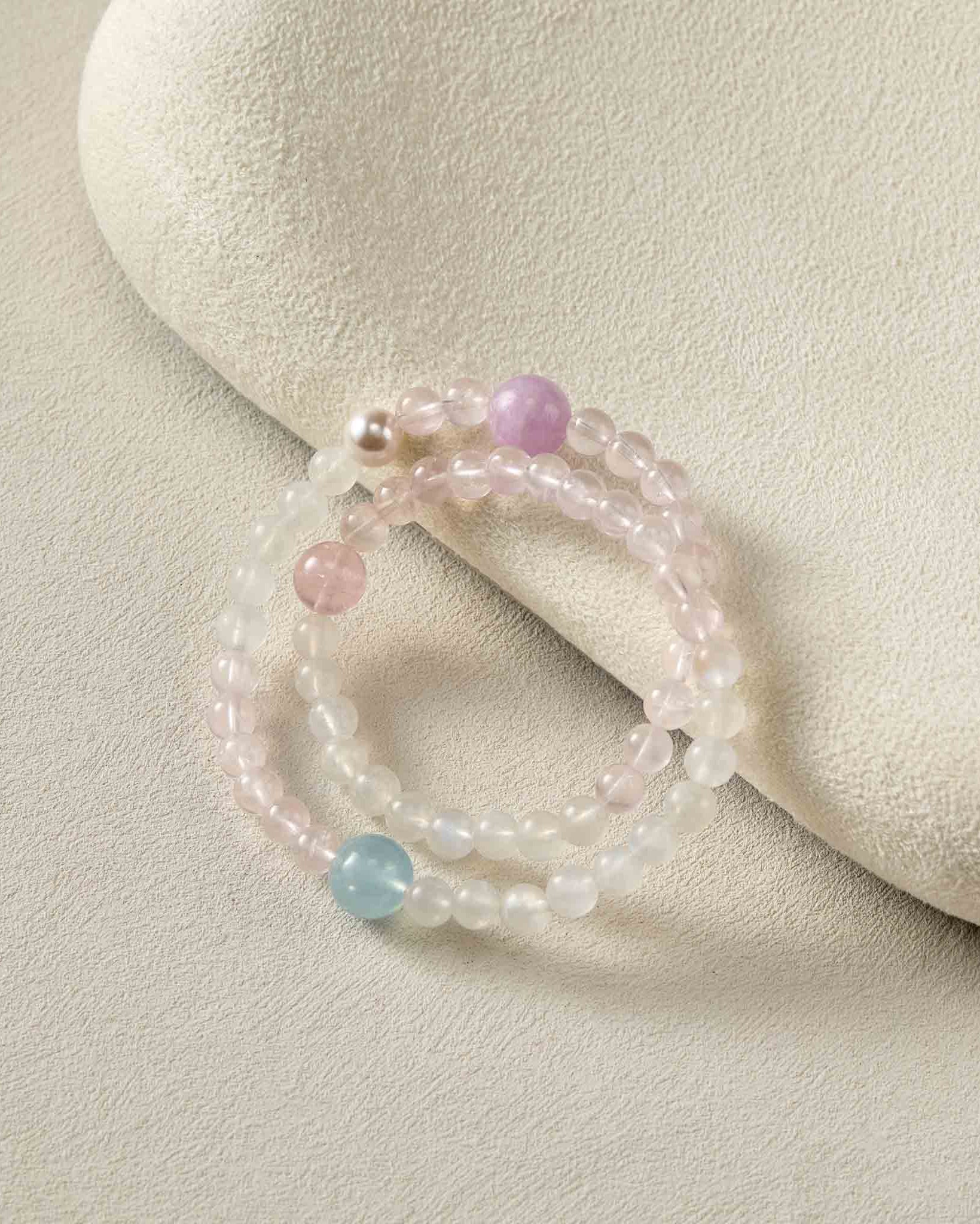 Beaded bracelet with pink and blue beads on a beige stone background