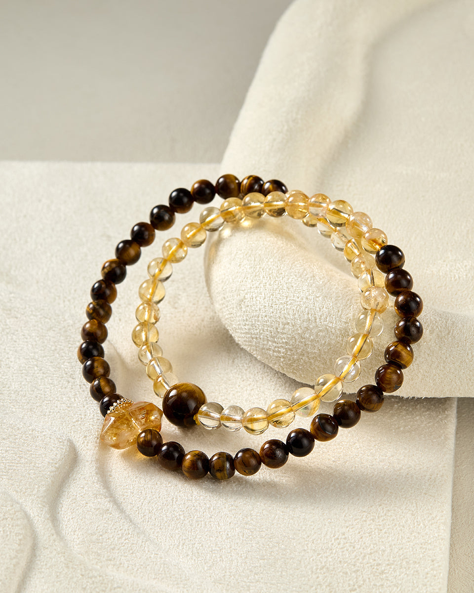 Two beaded bracelets on a white fabric background