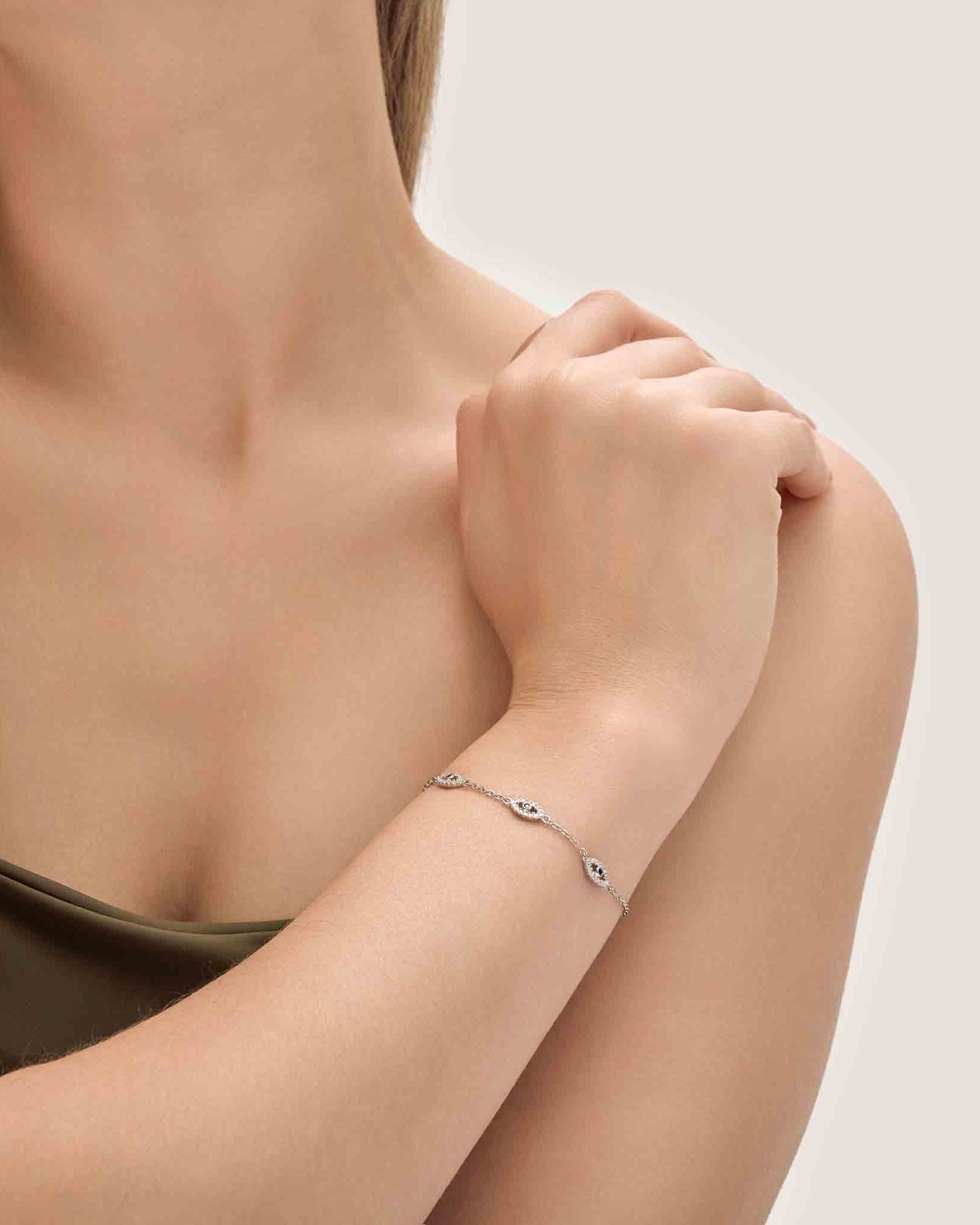 Woman wearing a delicate bracelet on a neutral background