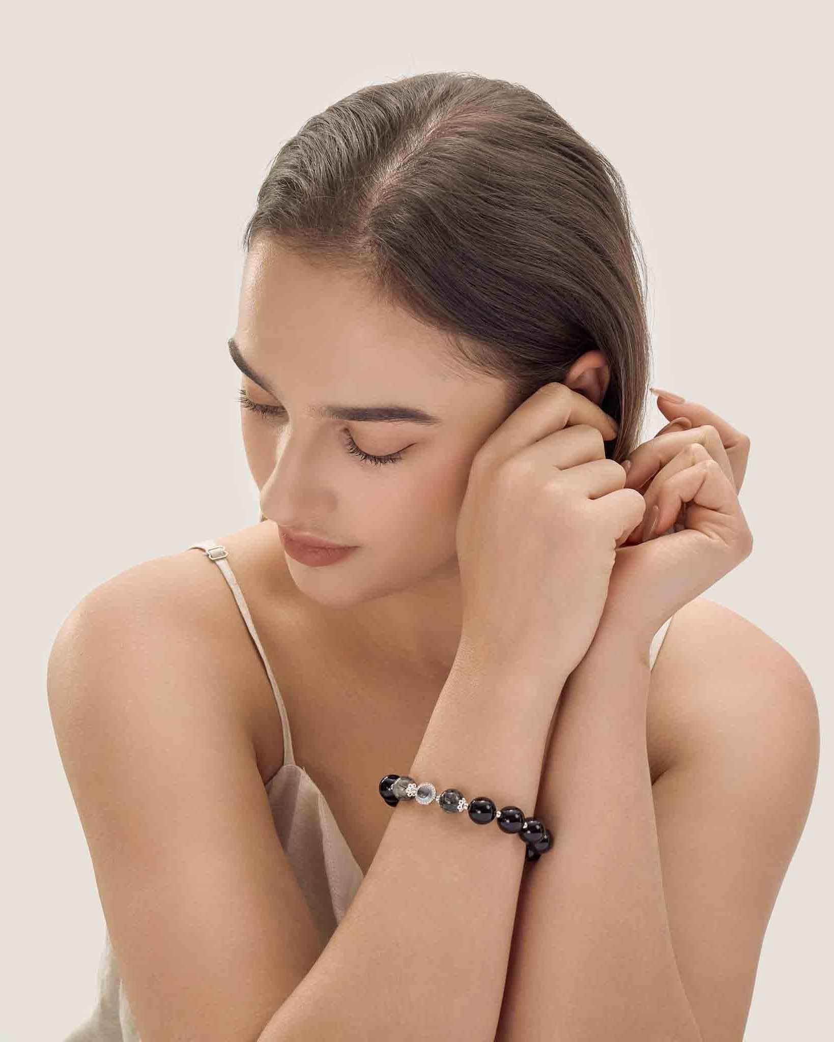 Woman wearing a bracelet with a plain background