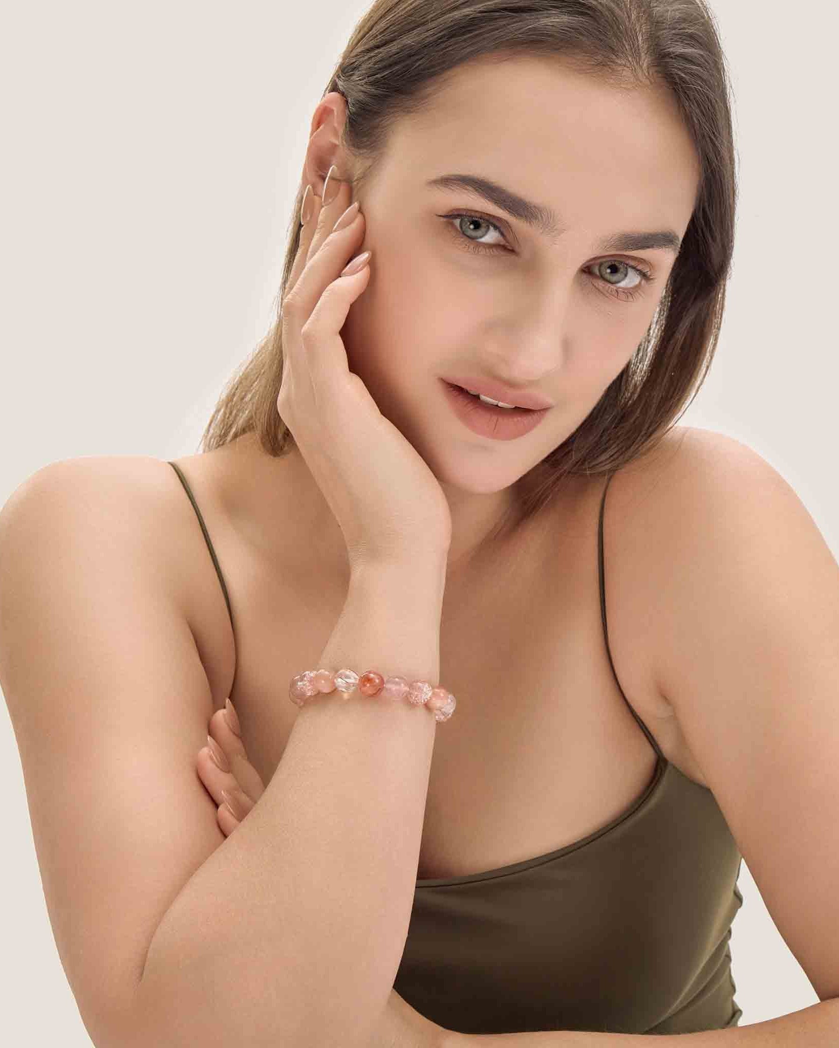 Woman wearing a bracelet on a plain background