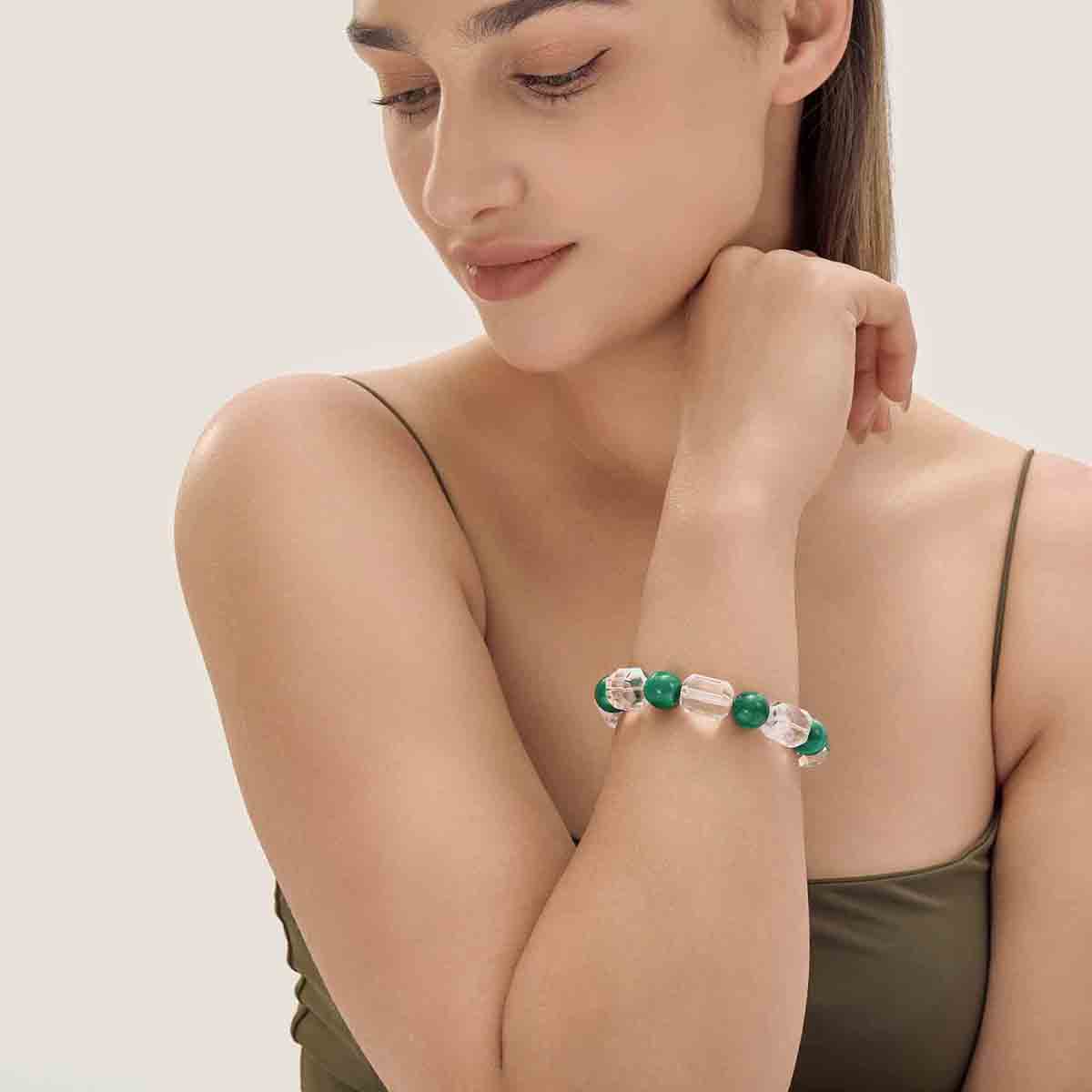 Choodo minimalist natural Malachite and square Clear Quartz crystal bracelet worn on a model's wrist, styled with a luxurious green silk dress, intellectual fashion jewelry