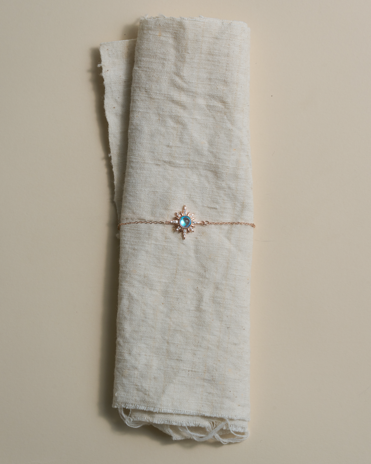 Choodo sun moonstone silver chain necklace wrapped around textured natural linen fabric