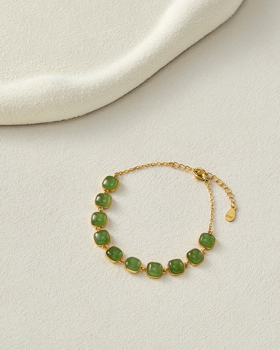 Flat lay of Choodo natural green Jade 925 sterling silver square geometric bracelet displayed on a luxurious cozy beige velvet tabletop, premium intellectual styling vibe.