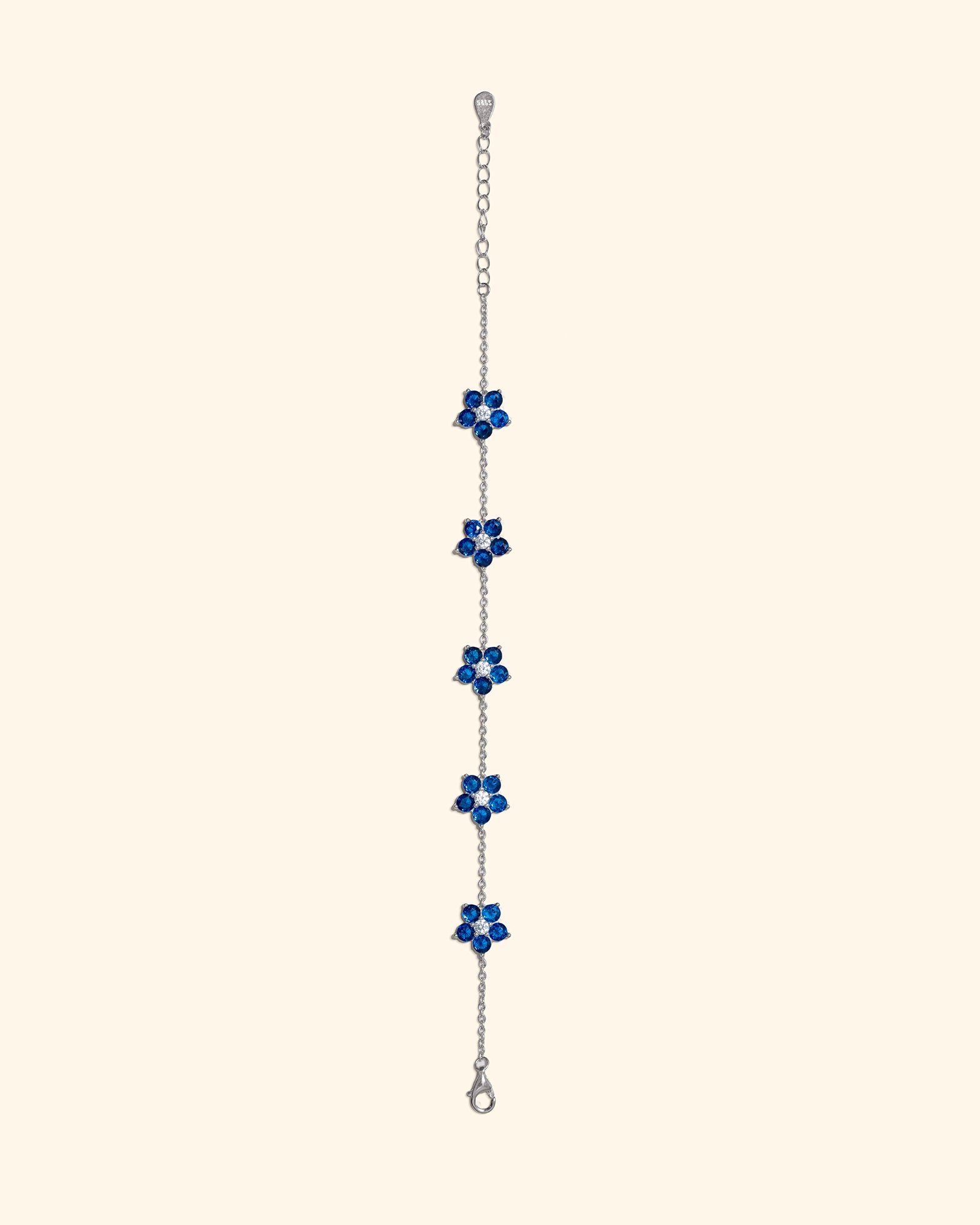 Choodo heavy craftsmanship 925 sterling silver bracelet featuring four delicate blue [CZ/enamel] flower charms on a cream background