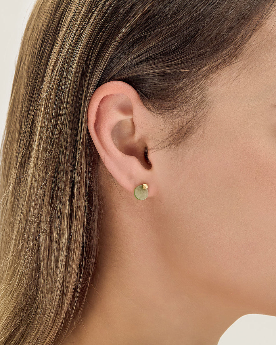 Choodo minimalist natural green Jade stud earrings styled on a model's ear, close up photo for an intellectual fashion look.